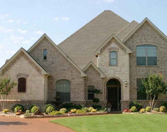 Stone home with warrantied roof by DG Contracting